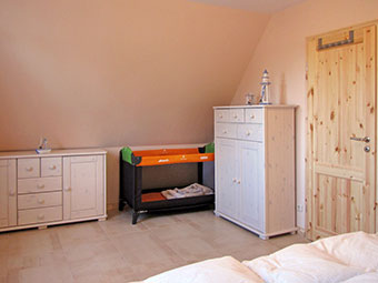 Ein Schlafzimmer mit Kinderbett im  Ferienhaus Silbermöwe